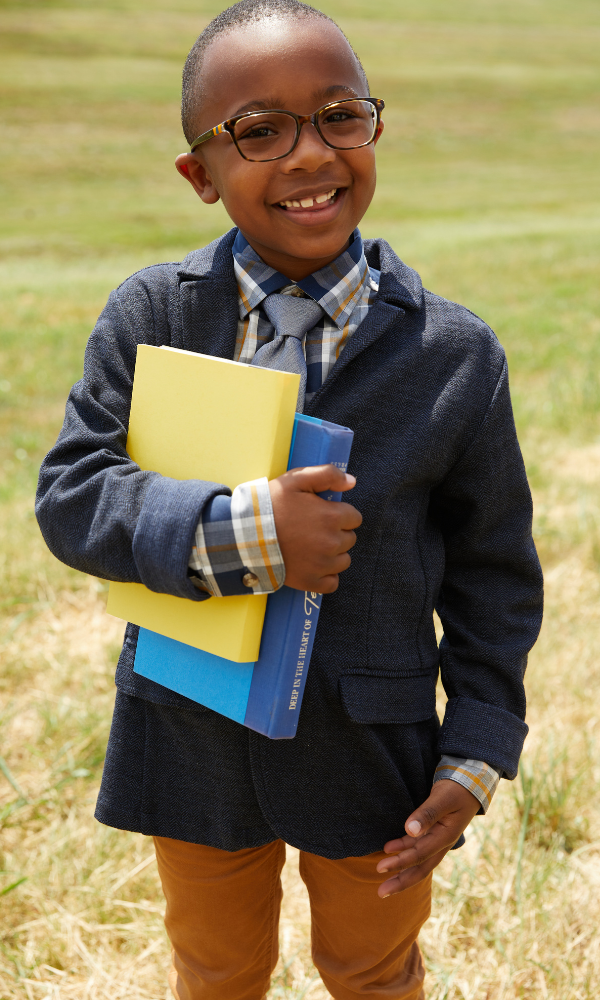 boy smiling holding books