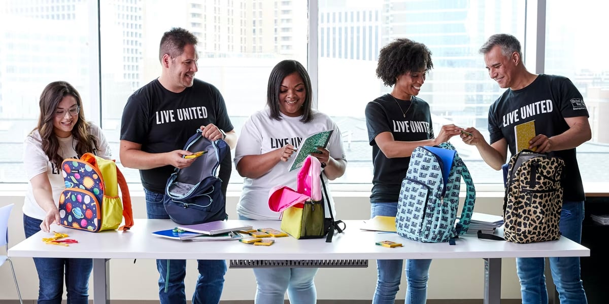 volunteers stuffing backpacks for school